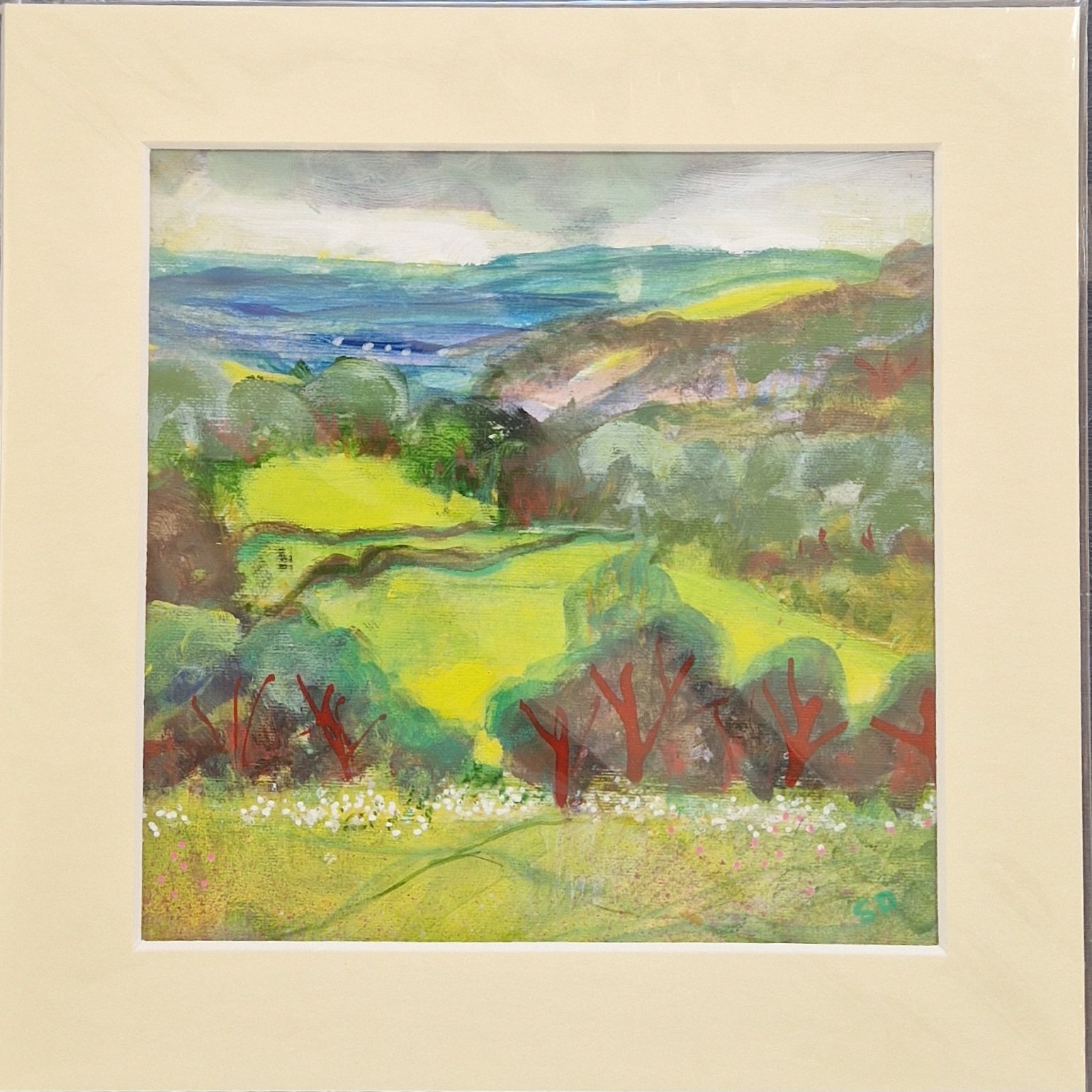 Storm Incoming original mixed media landscape by Sue Dewhurst showing vivid green fields, distant blue hills and trees beneath gathering storm clouds.